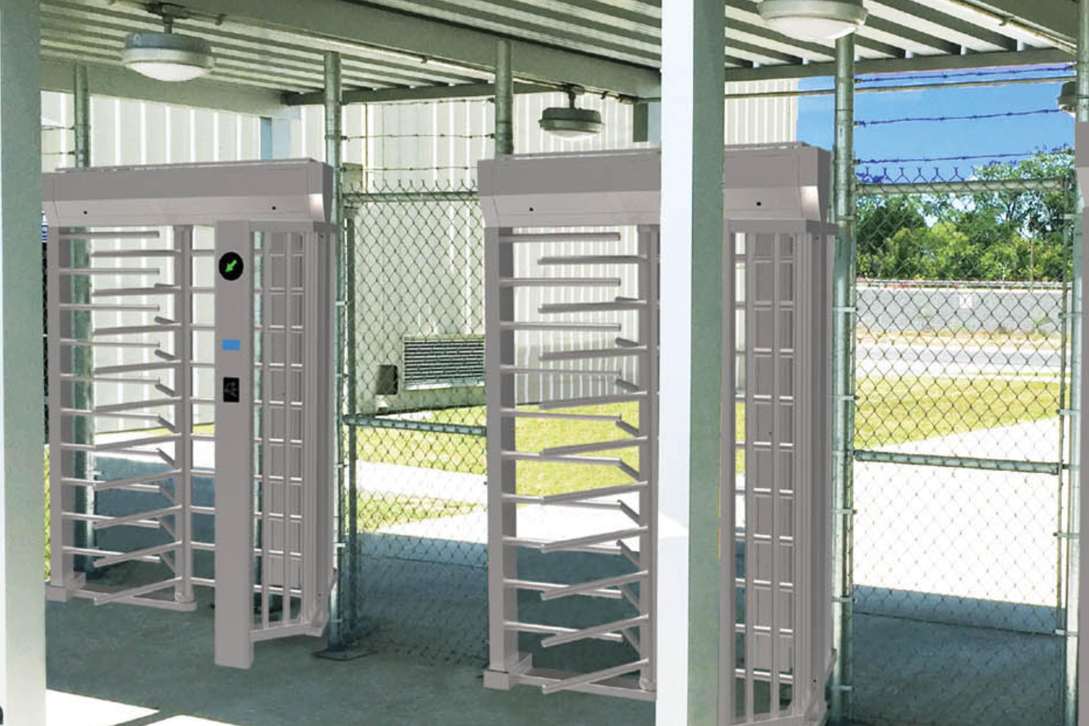 Full-height turnstiles at an outdoor site entrance under a canopy
