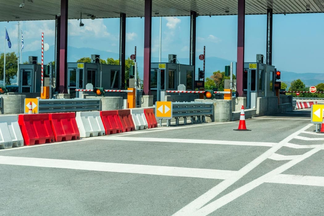 Multi-lane toll plaza with boom barriers controlling vehicle flow through each checkpoint lane
