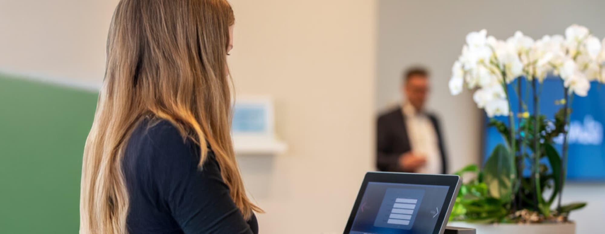Receptionist registering a visitor using visitor management software